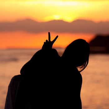 Young woman couple  silhouette bunny on sunset