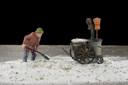 man cleaning the street from sand in the dark