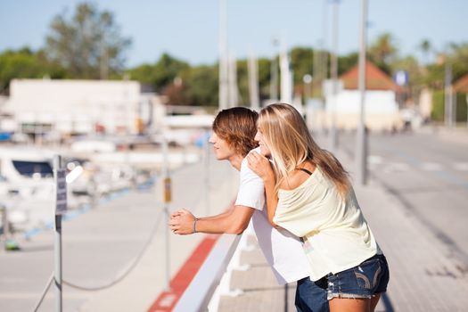 Young beautiful couple enjoying a walk by the harbour