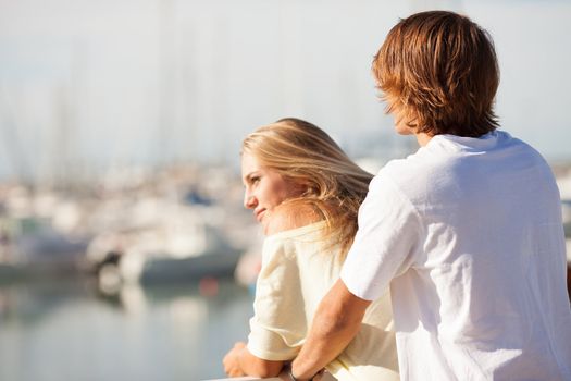 Young beautiful couple enjoying a walk by the harbour