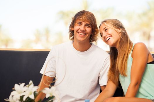 Young beautiful couple having fun in a beach bar