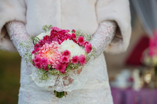 Bride holding purpur wedding bouquet in the yours hand