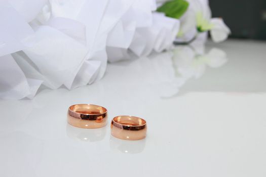 Wedding rings on a white background with wedding decorationsding Rings