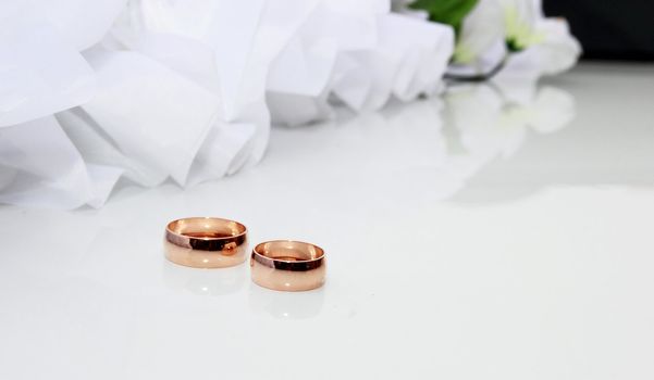 Wedding rings on a white background with wedding decorationsding Rings