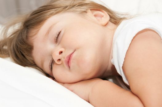 Sleeping little girl on bed