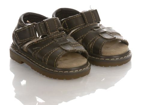leather infant or baby sandals with reflection on white background 

