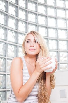 young beautiful woman drinks coffee on white cup