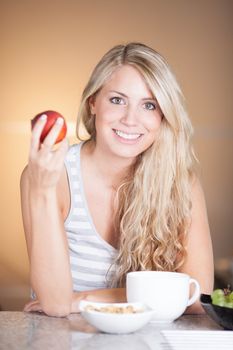 Young beautiful woman having a healthy breakfast in the kitchen