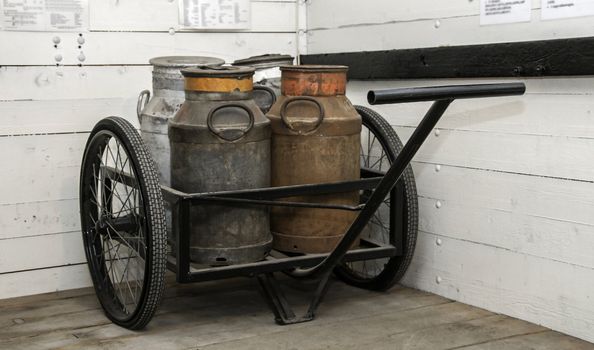 old handcar with churn and wooden background