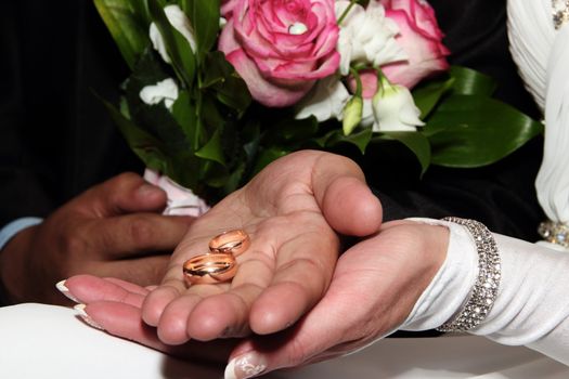 Wedding rings in hands of the newlyweds