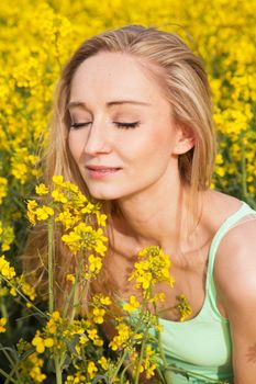 young beautiful blonde girl in a field in summer happy