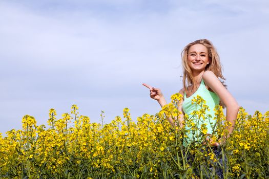 young beautiful blonde girl in a field in summer happy