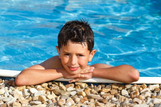 smiling boy in the swimming pool with clear water
