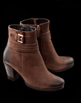modern female ankle boots over black background