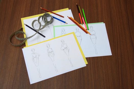 designer assessing fashion drawings on the collection of clothes