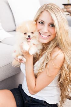 young woman playing with her tinny dog at home