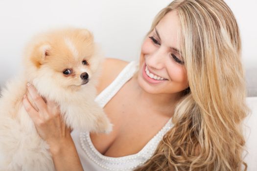 young woman playing with her tinny dog at home