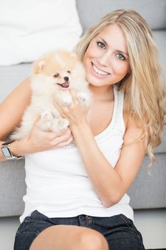 young woman playing with her tinny dog at home