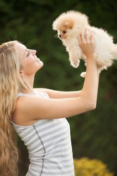 young woman playing with her tinny dog at home