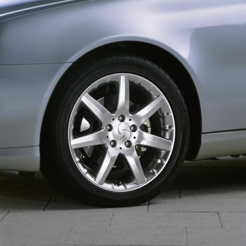 Metallic sport car wheel on the asphalt