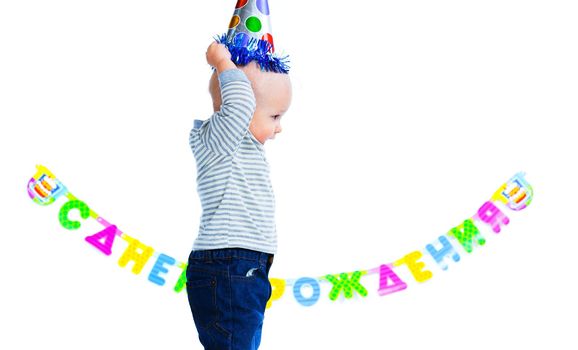Cute funny little boy in first birthday with colored balloons. In the studio