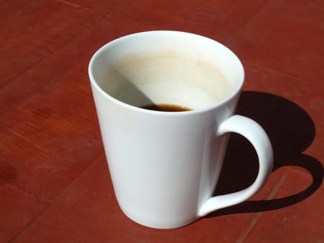 coffee in the sun in a white cup