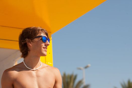 handsome man watching the sea on a lifeguard house