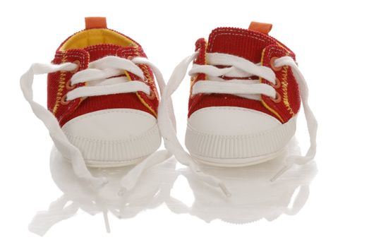 red infant or baby running shoes with reflection on white background