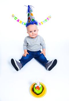 A little sweet boy with a cake and a candle in her first birthday.