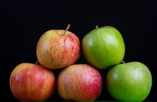 Apples in a row on black backround