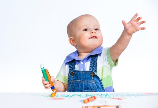Portrait clouse-up of little sweet boy draws with crayons in red, isolated on white
