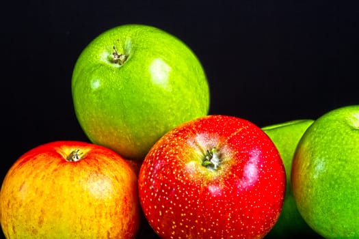 Apples in a row on black backround