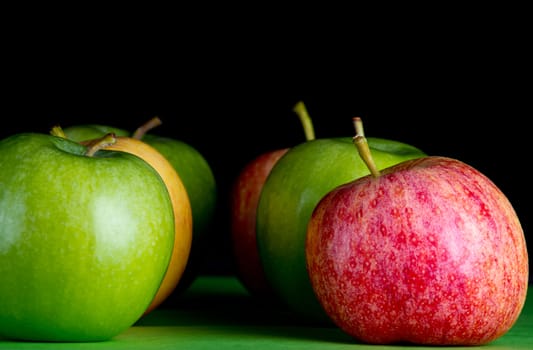 Apples in a row on black backround