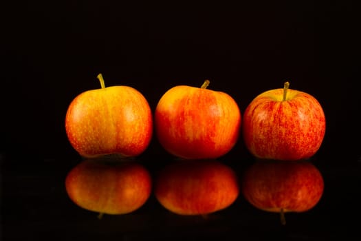 Apples in a row on black backround