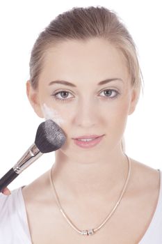young beautiful woman applying mineral powder on face isolated