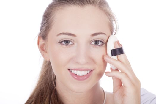 young beautiful woman applying mineral powder on face isolated