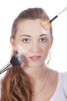 young beautiful woman applying mineral powder on face isolated