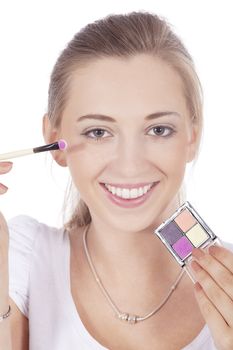 young beautiful woman applying eyeshadow on eyes isolated