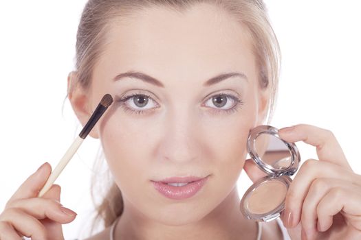 young beautiful woman applying eyeshadow on eyes isolated