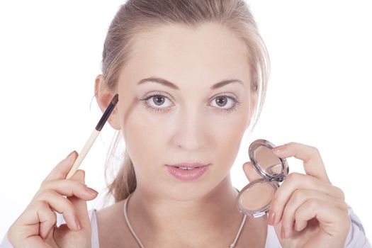 young beautiful woman applying eyeshadow on eyes isolated