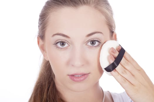 young beautiful woman applying mineral powder on face isolated