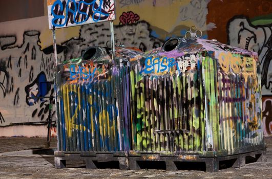 Picture of two tagged trashcans in a city