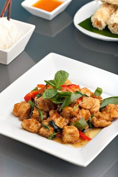 Fresh Thai food stir fry with stir fried tofu jasmine rice and crispy taro root crusted Thai spring rolls appetizer.