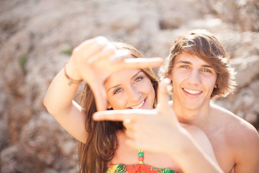 beautiful young couple having fun on the beach frame a picture