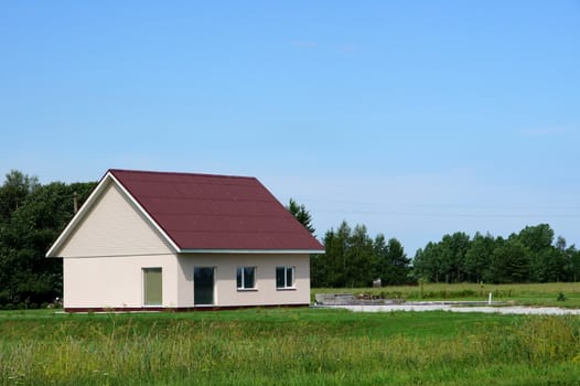 The house and field on a background of the sky