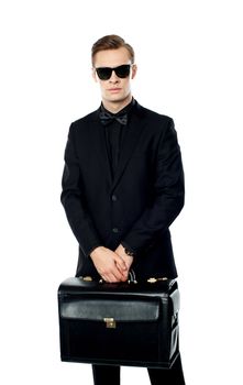 Young man carrying briefcase and wearing sunglasses