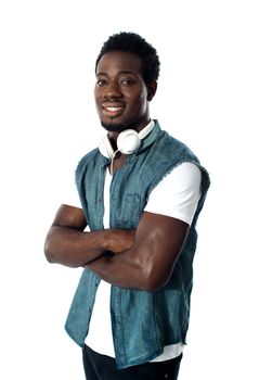 Man standing with headphones around his neck, arms crossed half length portrait