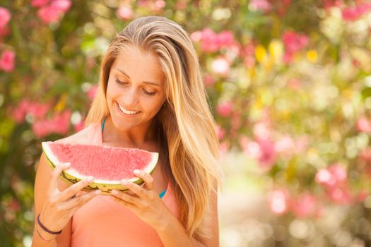 Portrait of a beautiful young woman eating watermelon