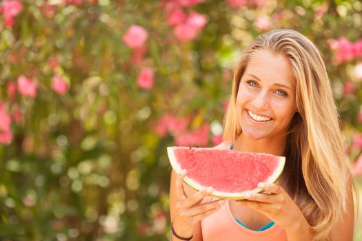 Portrait of a beautiful young woman eating watermelon