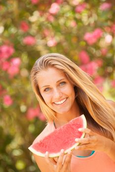 Portrait of a beautiful young woman eating watermelon